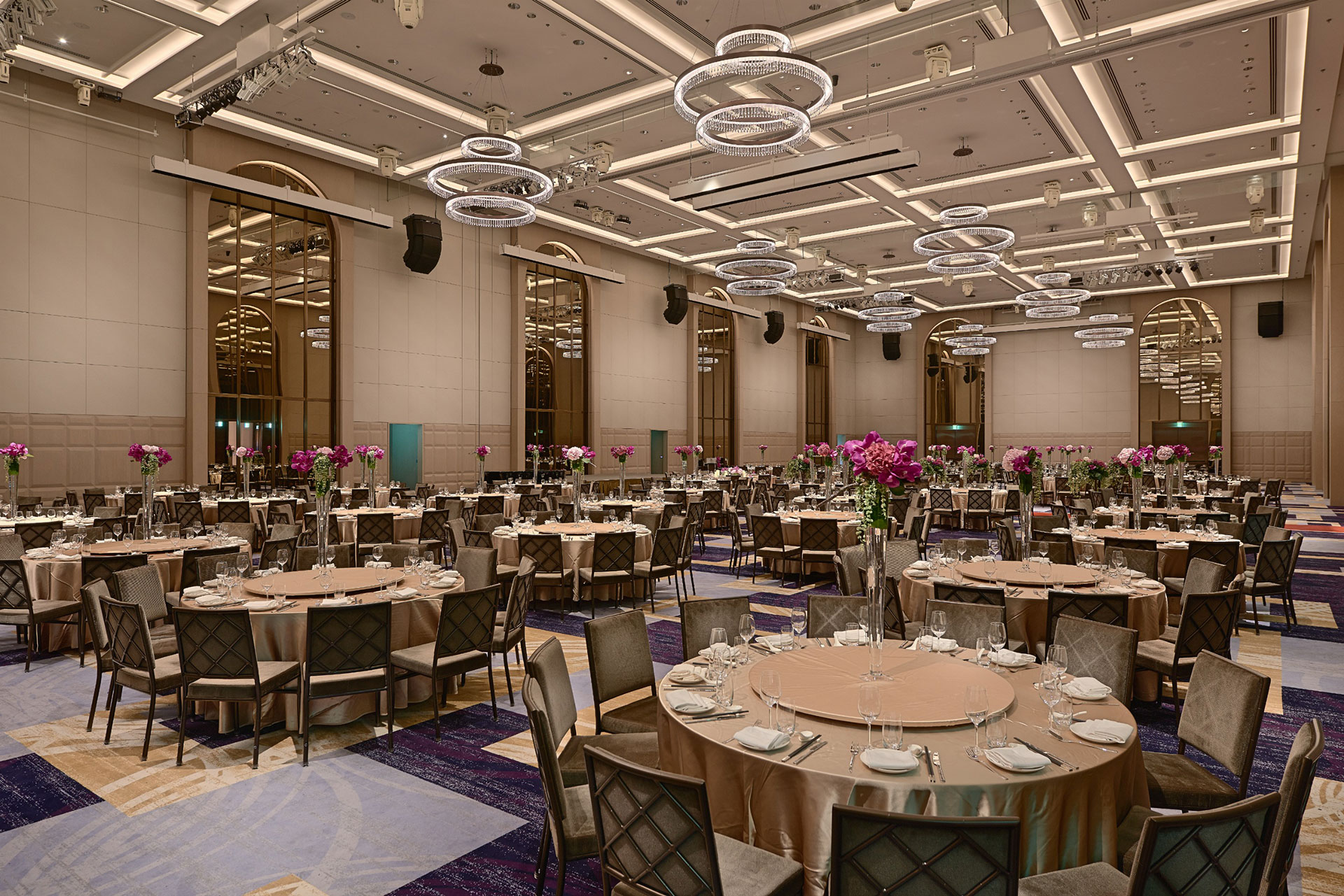 Grand Ballroom
萬豪廳
位在5樓，「萬豪廳」是台北萬豪酒店最具代表宴會廳，挑高9.9米，面積達381坪，是全台國際五星級飯店中最大的無樑柱宴會空間，可分成萬豪I廳(218坪)及萬豪II廳(163坪)，全廳打通總共可容納1,200名與會者。不論是50人的小型派對，或是80桌的大型饗宴，皆能發揮的淋漓盡致!
懸掛於廳內的10盞水晶吊燈，其三層環狀的施華洛世奇水晶與大量運用之金屬及玻璃材質，為宴會廳挑高的寬敞空間，創造出更豐富的層次感;全區採用頂級愛爾蘭知名品牌Britton地毯;音響設備，則採用55組BOSE漸變指向陣列揚聲器，提供無縫的垂直音場覆蓋，搭配300”和360”大型投影布幕，讓宴會廳各個角落都能享受演唱會般的優美聲光體驗。
宴會專案請洽(02)8502-3899